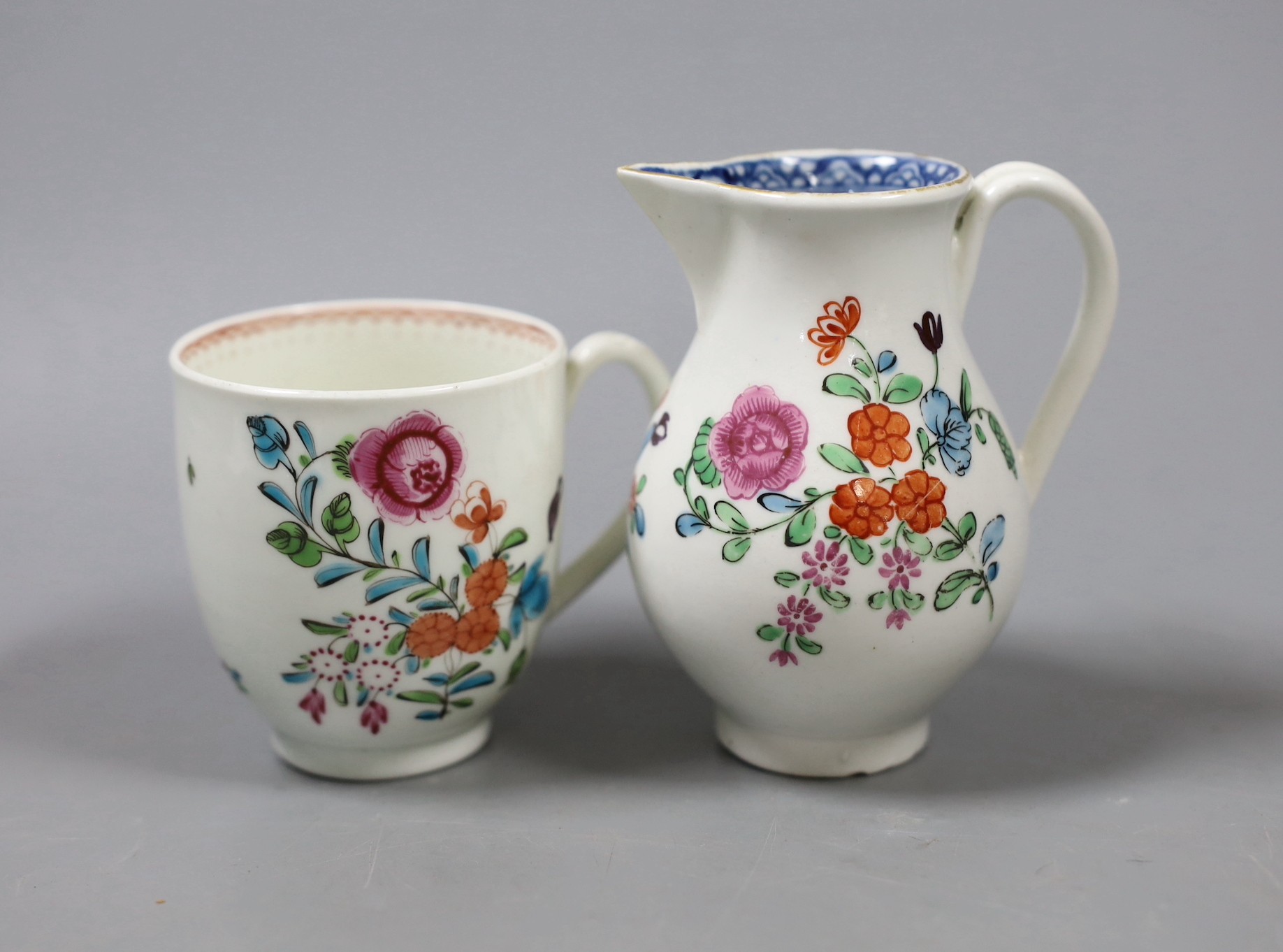 A Worcester sparrow beak jug, enamelled with flowers with an inner underglaze blue border and a similar coffee cup with a line loop and dot border. Tallest 9cm